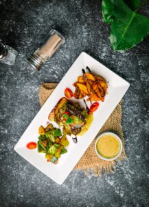 une assiette blanche garnie de viande et de légumes