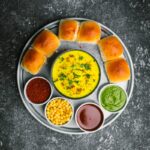 une assiette de nourriture comprenant du pain, des trempettes et des sauces
